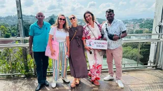 Guests holding a Sundown Tours board on a Sri Lanka viewpoint